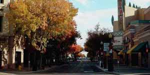 Modesto street lined with colorful autumn trees and local shops, reflecting the town’s welcoming atmosphere