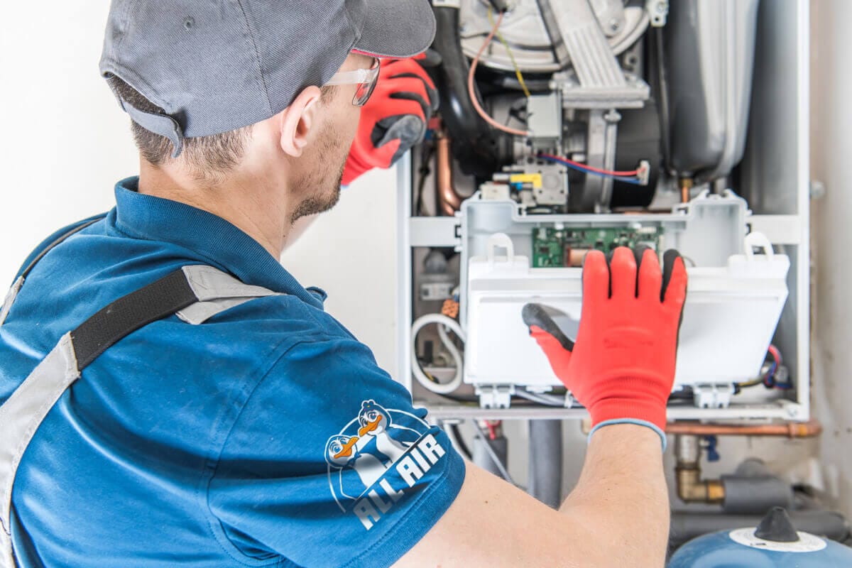 Friendly All Air HVAC technicians working together on rooftop air conditioning repair, providing expert service for reliable heating and cooling solutions