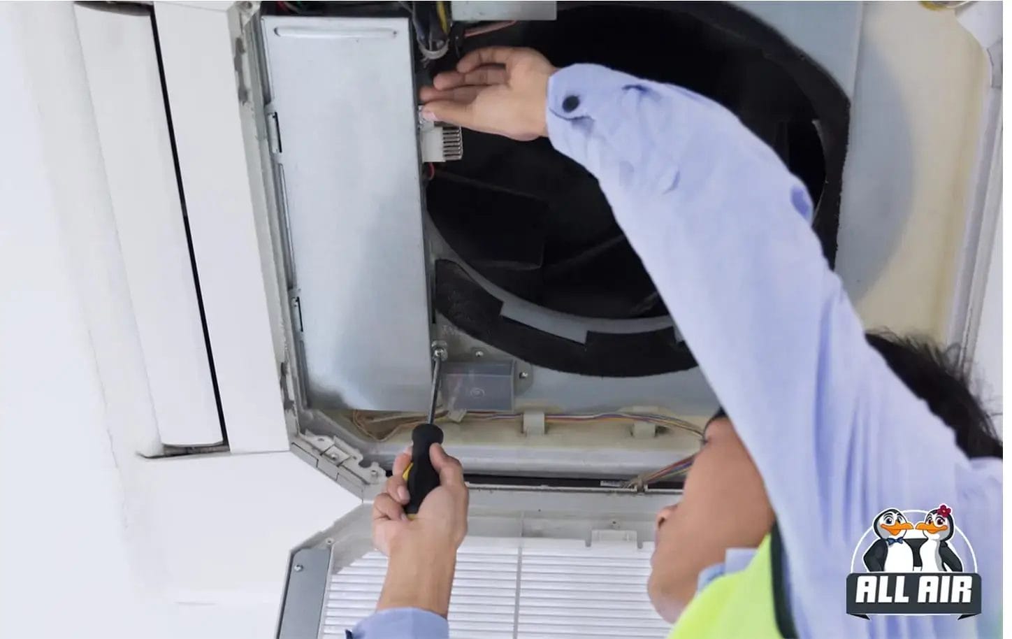 HVAC technician installing ceiling unit to improve indoor air quality