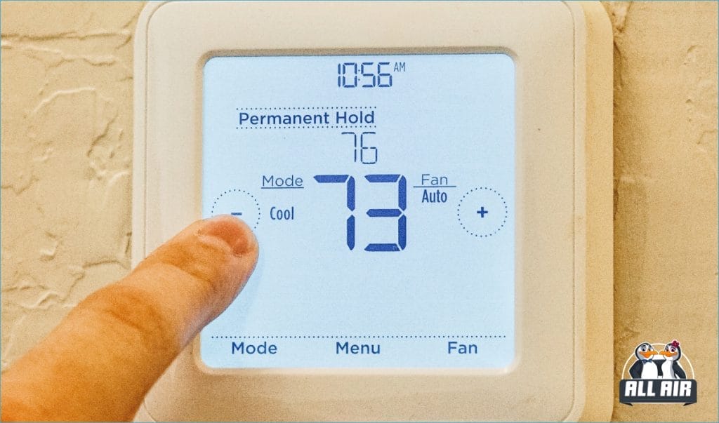 Closeup of an adult male finger adjusting the temperature on a thermostat